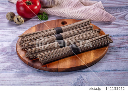 Soba noodles on wooden board with tomato garlic and quail eggs Soba noodles on wooden board with tomato garlic and quail eggs 141153952