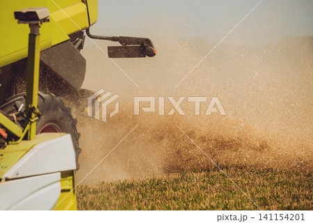 Combine harvester in action on wheat field. Process of gathering a ripe crop. Combine harvester in action on wheat field. Process of gathering a ripe crop. 141154201