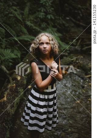 Teenage Girl in Striped Dress in a Forest Setting Teenage Girl in Striped Dress in a Forest Setting 141155230