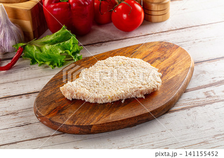 Breaded chicken cutlet on wooden board with fresh vegetables Breaded chicken cutlet on wooden board with fresh vegetables 141155452