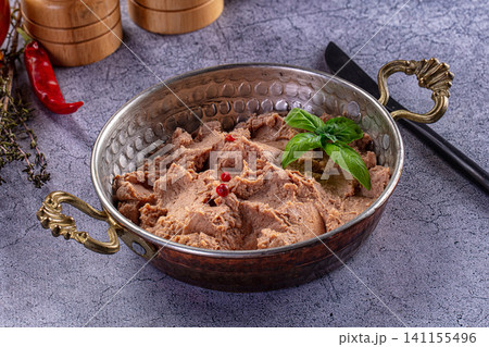Creamy bean dip in hammered metal bowl with basil and red peppercorns Creamy bean dip in hammered metal bowl with basil and red peppercorns 141155496
