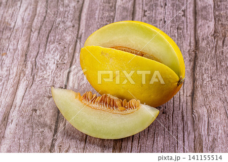 Sliced yellow melon on rustic wooden surface 141155514