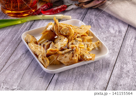 Marinated artichoke hearts on white plate with red chili and green onion Marinated artichoke hearts on white plate with red chili and green onion 141155564