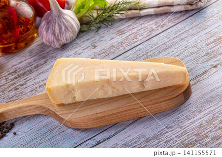 Italian hard cheese on a rustic wooden table with fresh culinary ingredients 141155571