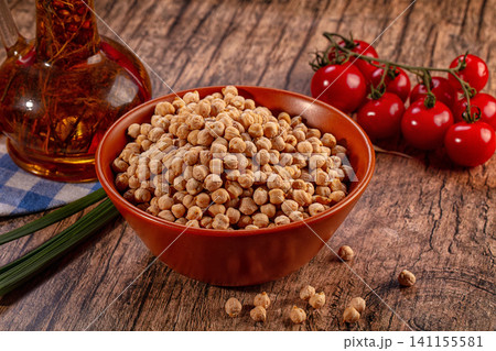 Bowl of chickpeas, fresh cherry tomatoes, olive oil, and green onions on rustic wooden table Bowl of chickpeas, fresh cherry tomatoes, olive oil, and green onions on rustic wooden table 141155581