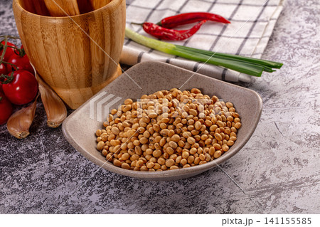 Dry soybeans, fresh cherry tomatoes, garlic, chili peppers, green onions, mortar on rustic background Dry soybeans, fresh cherry tomatoes, garlic, chili peppers, green onions, mortar on rustic background 141155585