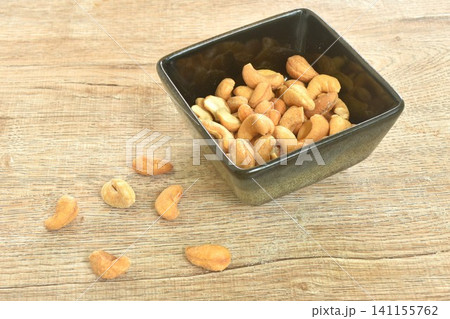 roasted salty cashew nuts arranging in black square cup on table roasted salty cashew nuts arranging in black square cup on table 141155762