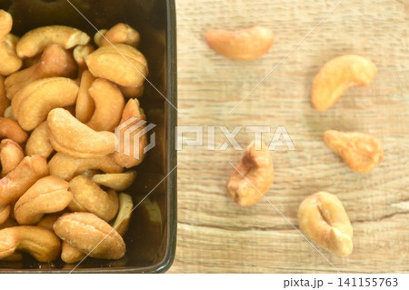 roasted salty cashew nuts arranging in black square cup on table roasted salty cashew nuts arranging in black square cup on table 141155763