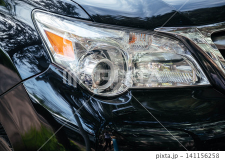 Close-up of the headlight of a modern car. Car front optics. Car headlight. Close-up of the headlight of a modern car. Car front optics. Car headlight. 141156258