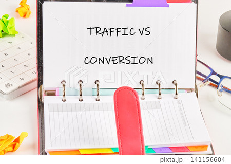 The scene shows an open planner that displays the topic of traffic versus conversion. Colorful notes and office tools are placed around the planner The scene shows an open planner that displays the topic of traffic versus conversion. Colorful notes and office tools are placed around the planner 141156604
