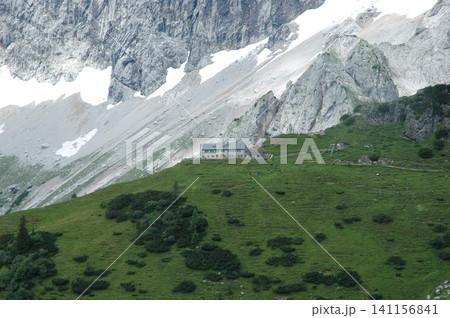 Alpine mountain hut Dachsteinsuedwandhuette below the rock face Alpine mountain hut Dachsteinsuedwandhuette below the rock face 141156841