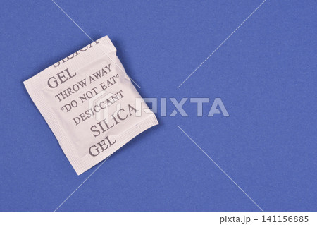 Silica Gel Desiccant Packet on Blue Background Silica Gel Desiccant Packet on Blue Background 141156885