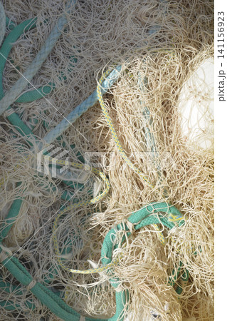 Tangled commercial fishing net with green ropes full frame. Tangled commercial fishing net with green ropes full frame. 141156923