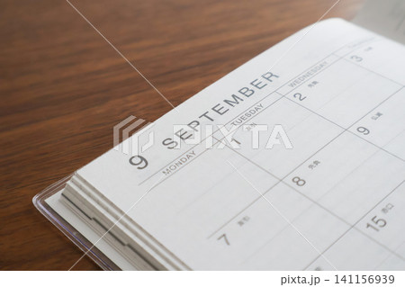 机の上に開いて置いた9月のスケジュール帳 机の上に開いて置いた9月のスケジュール帳 141156939
