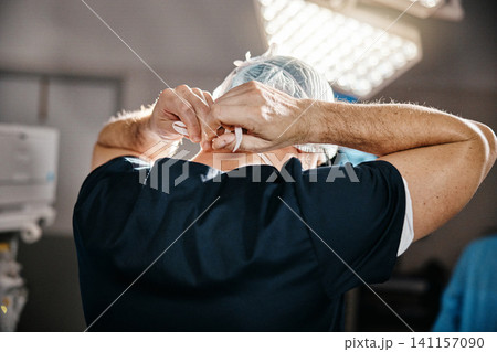 Healthcare, cap and doctor in theatre for safety, cardiovascular surgery and protection in hospital. Emergency, surgeon and man with getting ready for operation, preparation or medical procedure 141157090