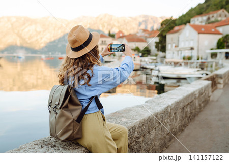 Beautiful female tourist walks the streets, photographed attractions. Lifestyle, rest, active life. Beautiful female tourist walks the streets, photographed attractions. Lifestyle, rest, active life. 141157122