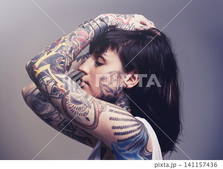 Tattoo, edgy design and rebel with woman, punk rock and tradition on a grey studio background. Profile, person and model with ideas or creative with emo and gothic art with ink, trendy or heavy metal Tattoo, edgy design and rebel with woman, punk rock and tradition on a grey studio background. Profile, person and model with ideas or creative with emo and gothic art with ink, trendy or heavy metal 141157436