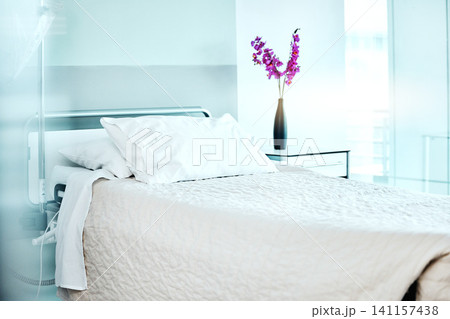 Flowers, empty and bed at medical hospital for sickness, injury or surgery recovery or resting. Pillow, blanket and comfortable modern interior of ward with floral plant in healthcare clinic. 141157438