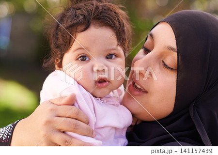 Muslim woman, mother and baby with hug for love, care and bonding during Eid in Cape Town, South Africa. Female person, child and family together outdoor in nature, garden and backyard with affection 141157439