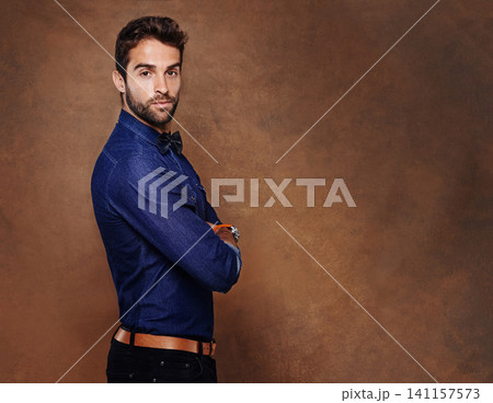 Fashion, portrait and business man in studio with arms crossed for confidence, serious or corporate on brown background. Entrepreneur, consultant and male person for formal, styling or trendy clothes 141157573