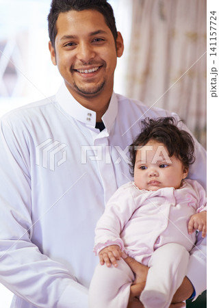 Muslim, happy and portrait of father with baby in home for bonding, relationship and calm together. Parenting, family and Islamic dad with newborn infant for love, childcare or support in living room 141157724