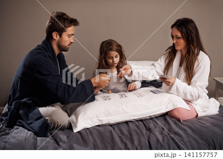 Parents, girl and fun while playing cards in home for bonding, learning and relax with strategy in bedroom. Father, mother and daughter with games, maths and teaching with connection in family house Parents, girl and fun while playing cards in home for bonding, learning and relax with strategy in bedroom. Father, mother and daughter with games, maths and teaching with connection in family house 141157757