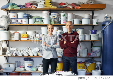 Businessman, woman and equipment in workshop for maintenance, manufacturing and job confidence. Senior person, arms crossed and mature contractor with paint for repairs, renovation or remodeling Businessman, woman and equipment in workshop for maintenance, manufacturing and job confidence. Senior person, arms crossed and mature contractor with paint for repairs, renovation or remodeling 141157782