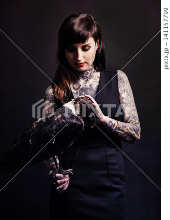 Fashion, woman and bird animal in studio for witchcraft or magic, mysterious and fantasy with punk culture. Person, eagle and isolated on black background for darkness and creepy grunge look. 141157799
