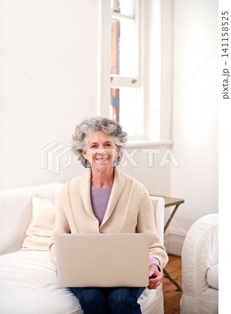 Laptop, sofa and portrait of elderly woman in living room for movie, weekend and enjoyment. Relax, smile and senior person with digital technology for happiness, streaming and retirement at home 141158525