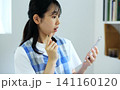 スマホを見て驚くエプロン姿の女性 141160120
