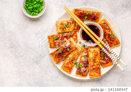Dumplings are arranged on a plate with a small bowl of dipping sauce Dumplings are arranged on a plate with a small bowl of dipping sauce 141160547