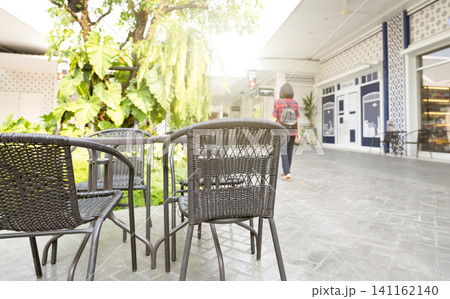 Outdoor table of coffee cafe and reataurant in summer day. Summer terrace on city street. Empty outside tables and chairs of outdoor cafe on blur green garden. Cozy outdoor zone cafe and restaurant. Outdoor table of coffee cafe and reataurant in summer day. Summer terrace on city street. Empty outside tables and chairs of outdoor cafe on blur green garden. Cozy outdoor zone cafe and restaurant. 141162140
