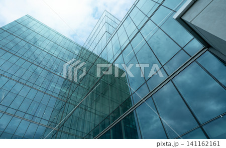 Modern sustainable glass office building. Exterior view of corporate headquarters glass building architecture. Energy-efficient building. Financial business center tower. Glass windows of company. Modern sustainable glass office building. Exterior view of corporate headquarters glass building architecture. Energy-efficient building. Financial business center tower. Glass windows of company. 141162161