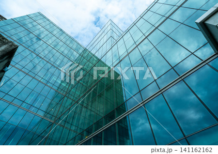 Modern sustainable green glass office building. Exterior view of corporate headquarters glass building architecture. Energy-efficient building. Financial business center. Glass windows of company. Modern sustainable green glass office building. Exterior view of corporate headquarters glass building architecture. Energy-efficient building. Financial business center. Glass windows of company. 141162162