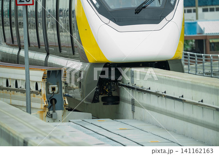 Elevated monorail train on rail. Guide wheels rubber tire on concrete guideway beam with conductor rail. Monorail technology. Modern mass transit. Rail transportation. Driverless straddle monorail. 141162163