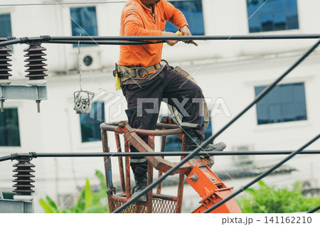 High voltage power line maintenance. Electrician at work. Electrical technician repairing cable wire. High voltage power line construction. Danger of wiring and electrical wires. Work with safety. High voltage power line maintenance. Electrician at work. Electrical technician repairing cable wire. High voltage power line construction. Danger of wiring and electrical wires. Work with safety. 141162210