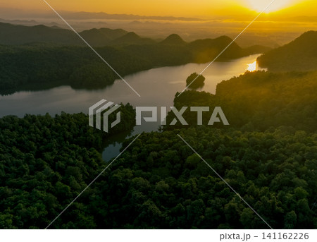 Beautiful landscape of green mountains and lake in the morning with sunrise sky. Nature landscape. Watershed forest. Water and forest sustainability concept. Aerial view of mountain with green trees. Beautiful landscape of green mountains and lake in the morning with sunrise sky. Nature landscape. Watershed forest. Water and forest sustainability concept. Aerial view of mountain with green trees. 141162226
