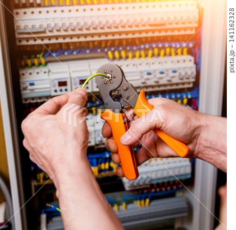 The man is repairing the switchboard voltage with automatic switches. 141162328