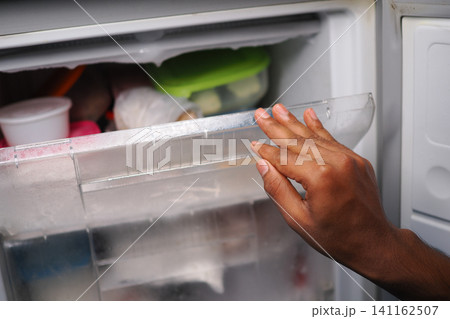 Opening a freezer door to check on food storage 141162507