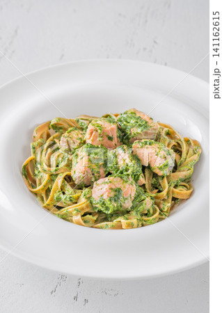 Whole grain tagliatelle pasta with salmon spinach in creamy sauce gourmet dish Whole grain tagliatelle pasta with salmon spinach in creamy sauce gourmet dish 141162615