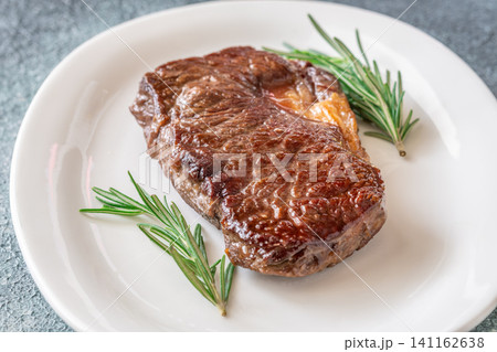 Perfectly grilled beef steak with rosemary on white plate premium restaurant presentation Perfectly grilled beef steak with rosemary on white plate premium restaurant presentation 141162638