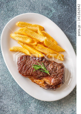 Grilled beef steak with fries and rosemary on white plate classic meal 141162642