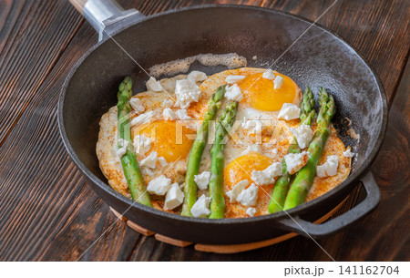 Rustic Breakfast Skillet With Fried Eggs Asparagus And Feta Cheese 141162704