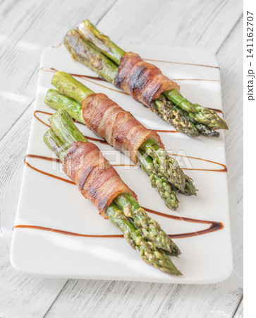 Gourmet Bacon Wrapped Asparagus With Balsamic Glaze On White Ceramic Plate Gourmet Bacon Wrapped Asparagus With Balsamic Glaze On White Ceramic Plate 141162707