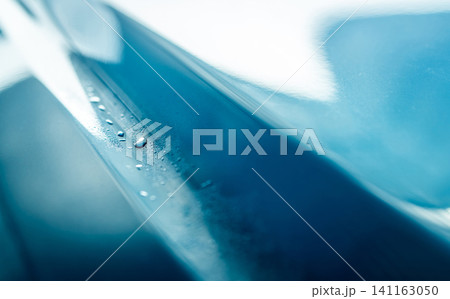 Closeup shiny blue car texture with water drops. Blue car is washing with water. Auto care business. Car with drops of water after cleaning with high pressure water spray. Car cleaning before waxing. Closeup shiny blue car texture with water drops. Blue car is washing with water. Auto care business. Car with drops of water after cleaning with high pressure water spray. Car cleaning before waxing. 141163050