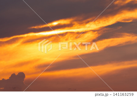 Beautiful sunset sky. Golden sunset sky with beautiful pattern of clouds. Orange, yellow, and dark clouds in the evening. Freedom and calm background. Beauty in nature. Peaceful and spiritual scene. Beautiful sunset sky. Golden sunset sky with beautiful pattern of clouds. Orange, yellow, and dark clouds in the evening. Freedom and calm background. Beauty in nature. Peaceful and spiritual scene. 141163259