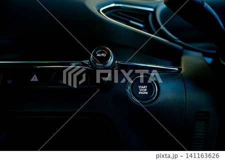 Start stop engine button of luxury car. Push up button for start or stop car engine in keyless automobile. Turn key with ignition system concept. Black ignition switch. Car air conditioning knob. Start stop engine button of luxury car. Push up button for start or stop car engine in keyless automobile. Turn key with ignition system concept. Black ignition switch. Car air conditioning knob. 141163626