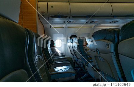 Blur Asian people wear face mask sit on passenger seat of airplane. Aviation business after coronavirus vaccine injection. Travel bubble. Social distancing prevent coronavirus. Seat inside of plane. Blur Asian people wear face mask sit on passenger seat of airplane. Aviation business after coronavirus vaccine injection. Travel bubble. Social distancing prevent coronavirus. Seat inside of plane. 141163645