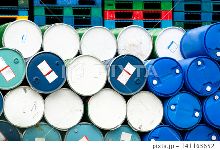 Old chemical barrels in front of stacked plastic pallet at the factory. Blue and green oil drum. Steel and plastic oil tank. Toxic waste warehouse. Hazard chemical barrel. Industrial waste in drums. Old chemical barrels in front of stacked plastic pallet at the factory. Blue and green oil drum. Steel and plastic oil tank. Toxic waste warehouse. Hazard chemical barrel. Industrial waste in drums. 141163652