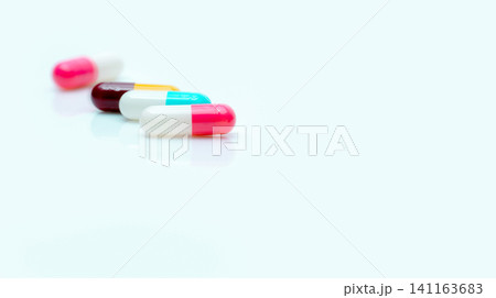 Selective focus on antibiotic capsule pill. Pharmaceutical industry. Prescription drugs. Pharmacy web banner. Pink, blue, yellow, red capsules pill on white background. Antibiotic drug resistance. Selective focus on antibiotic capsule pill. Pharmaceutical industry. Prescription drugs. Pharmacy web banner. Pink, blue, yellow, red capsules pill on white background. Antibiotic drug resistance. 141163683